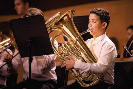 Aluno da Orquestra Kids do Musicarium tocando tuba