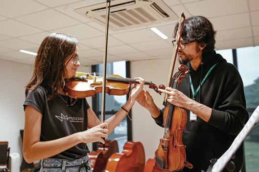 Professora orientando aluno em aula de violino no Musicarium